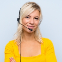 A person with a yellow top crossing their arms while wearing a headset