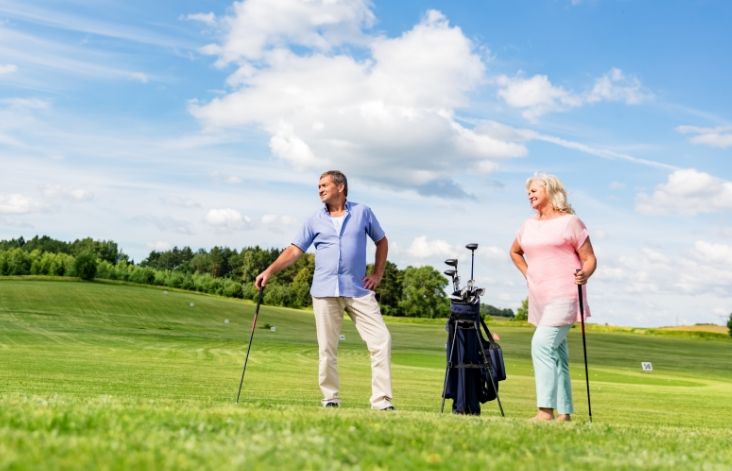 Two elderly people playing golf
